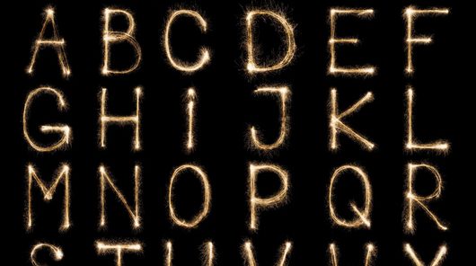Full english alphabet and numbers set made from burning sparkles on black background. Shiny festive firework latin font.