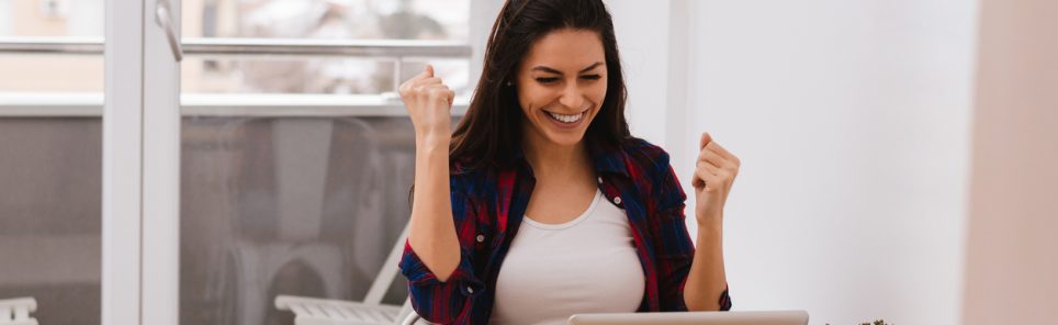surprised winner winning online watching a laptop at home