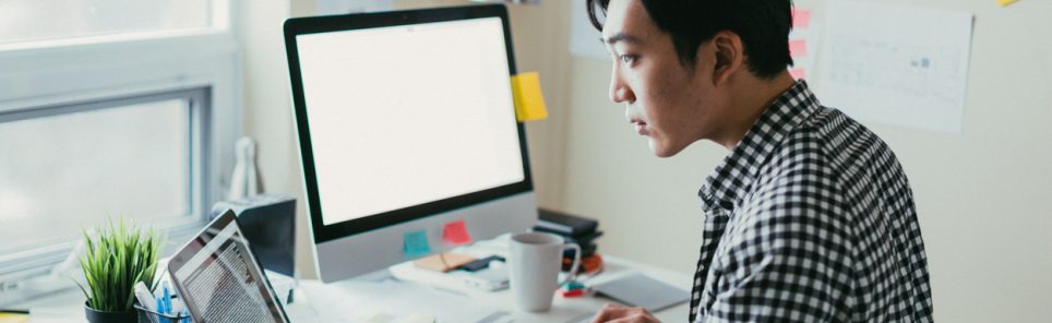 Asian man working at a comptuer