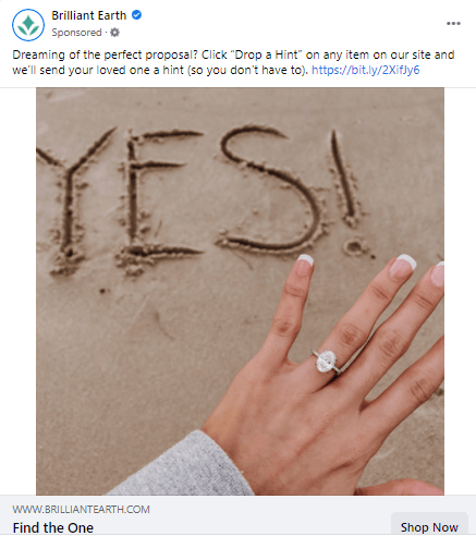 Facebook ad that features a woman with an engagement ring on her hand and "yes" etched in sand