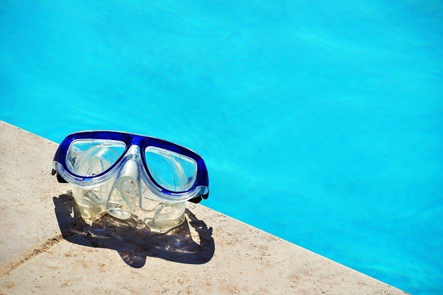 swimming goggles beside a pool