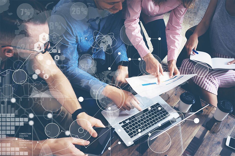 multiple people pointing to paper and pointing to laptop
