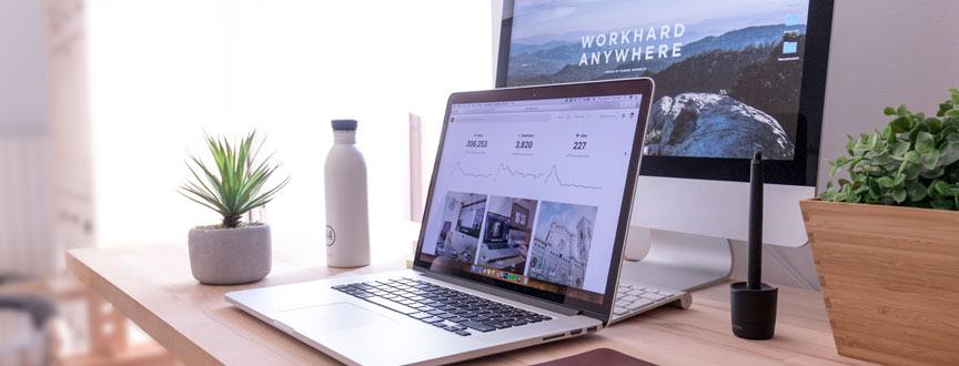 laptop sitting on desk by computer