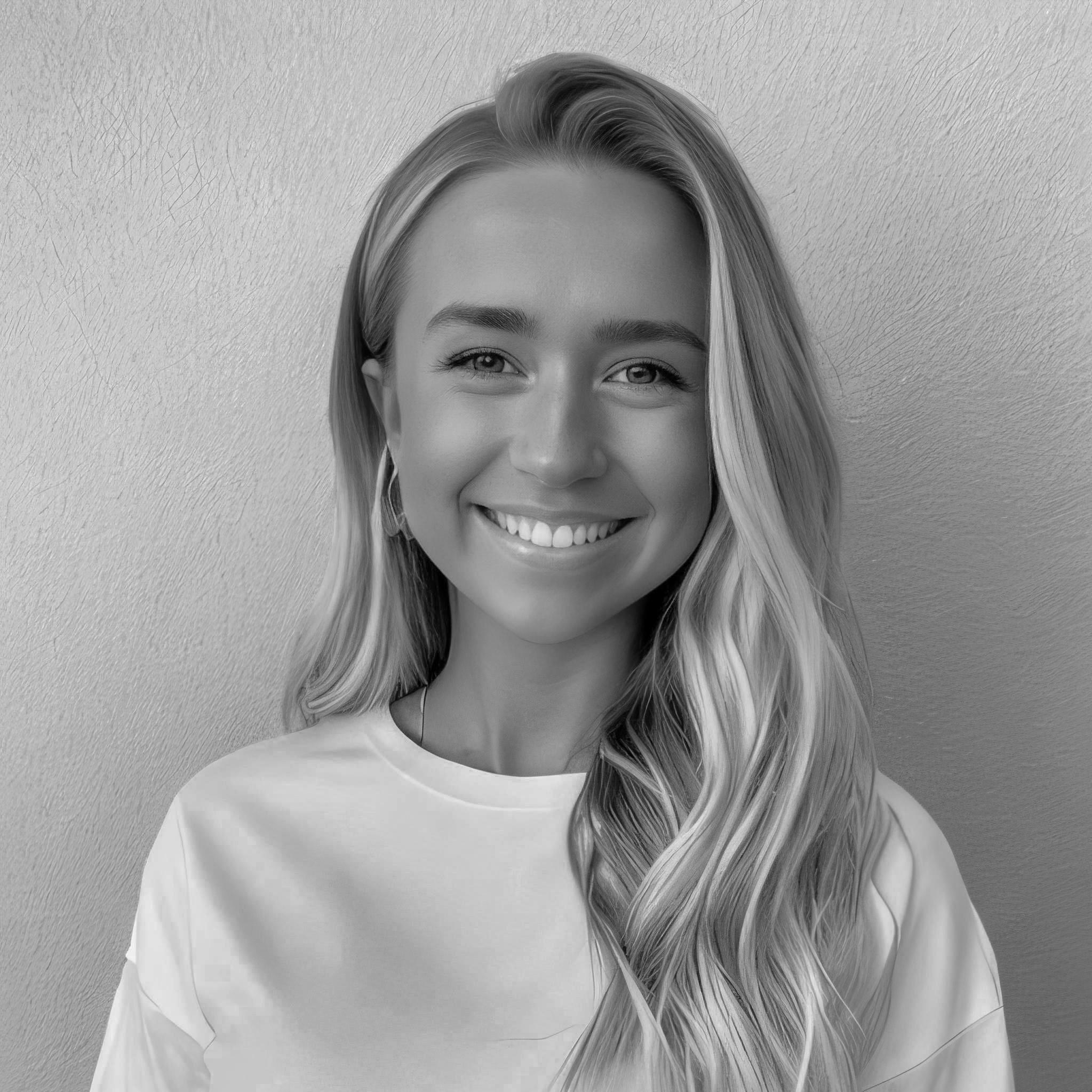 Portrait of a cheerful young woman with long blonde hair and a white t-shirt, smiling broadly against a neutral textured background.