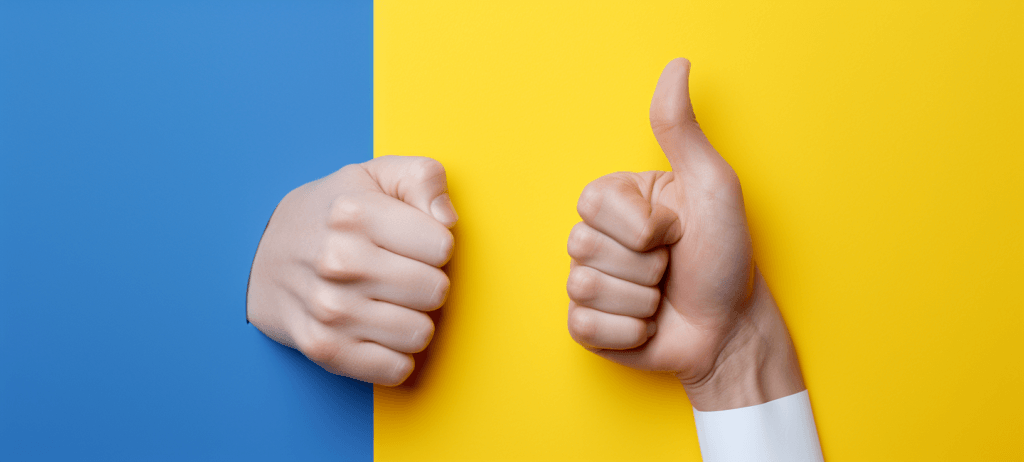 Two hands against a split blue and yellow background; one hand is in a fist on the blue side, and the other is giving a thumbs up on the yellow side.