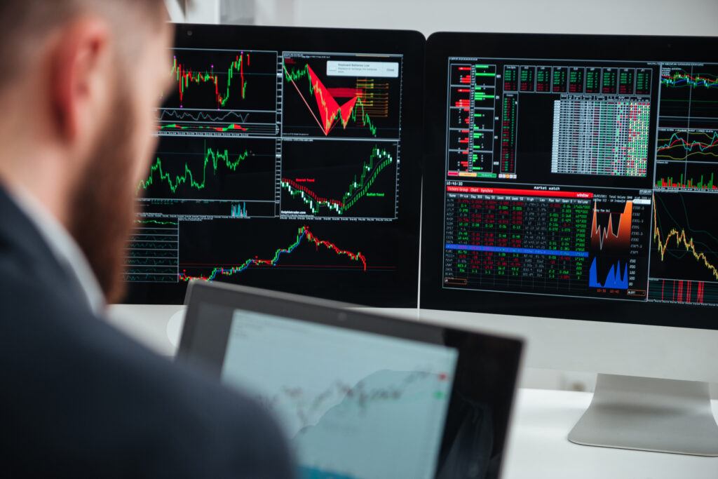 Closeup of monitors of computers with charts and graphs used by businessman in office