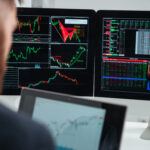 Closeup of monitors of computers with charts and graphs used by businessman in office