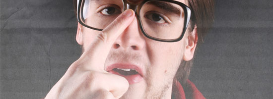 A person with glasses pushing up the bridge of their nose with their finger.