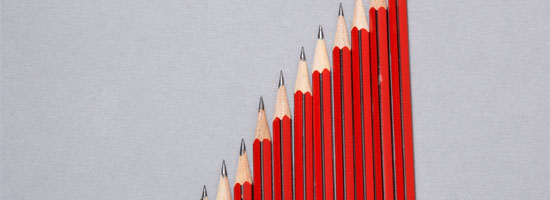 A series of red pencils arranged in ascending order to resemble a bar chart on a light grey background.