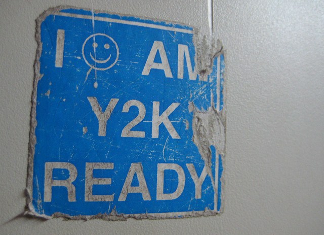 A worn and partially torn sticker with a blue background and white text that reads 'I AM Y2K READY' with a smiley face above the text.