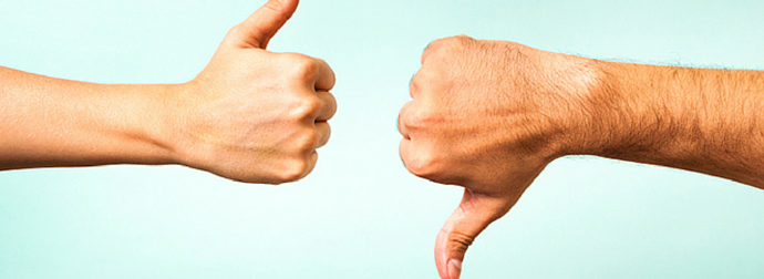 Two hands side by side, one with a thumbs-up and the other with a thumbs-down, against a light blue background.