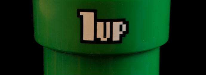 Close-up of a green cylindrical object with pixelated '1up' text.