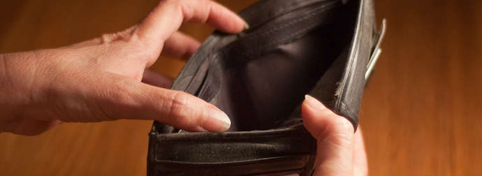 Hands holding an open, empty black leather wallet.