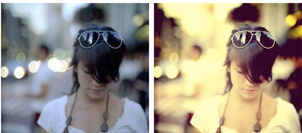 A young woman with sunglasses on her head, looking downward, wearing a white top and a dark necklace, with a blurred urban background with bokeh lights.