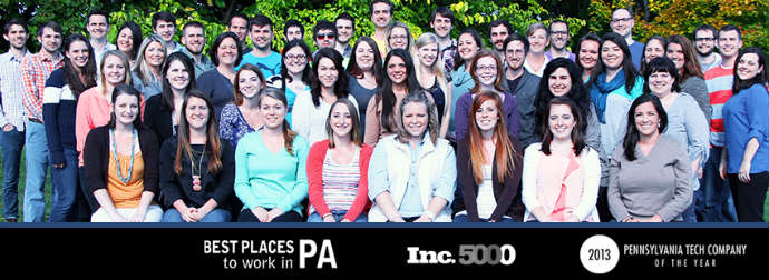 A group of people posing for a group photo outdoors with text overlays indicating awards for being a great place to work and a top tech company in Pennsylvania for the year 2013.