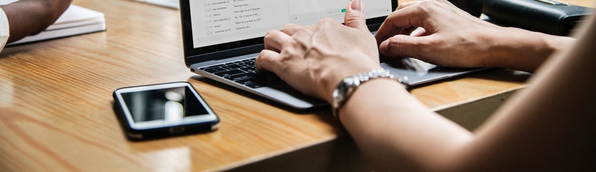 Adult sending email on laptop