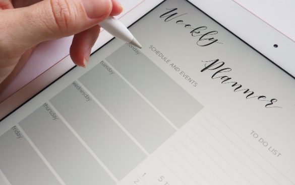 A person's hand using a stylus on a tablet showing a weekly planner with sections for days of the week and a to-do list.