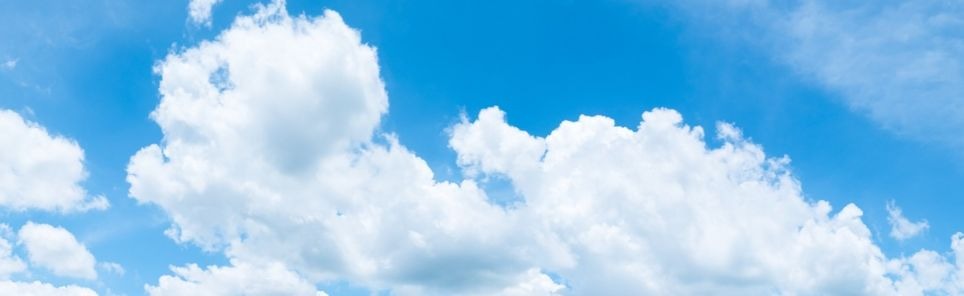 Panoramic view of a blue sky with scattered fluffy white clouds.