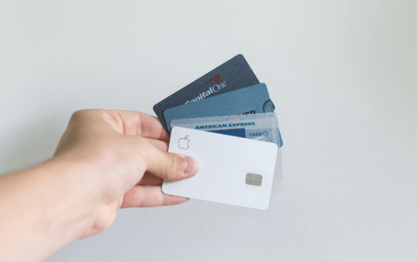 Person holding multiple credit cards fanned out