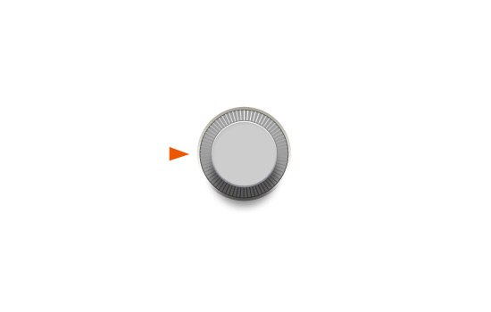 A grey round knob with ridges and an orange arrow indicating the turning direction.