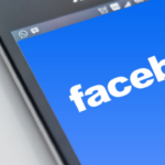 Close-up of a smartphone screen displaying the Facebook logo.