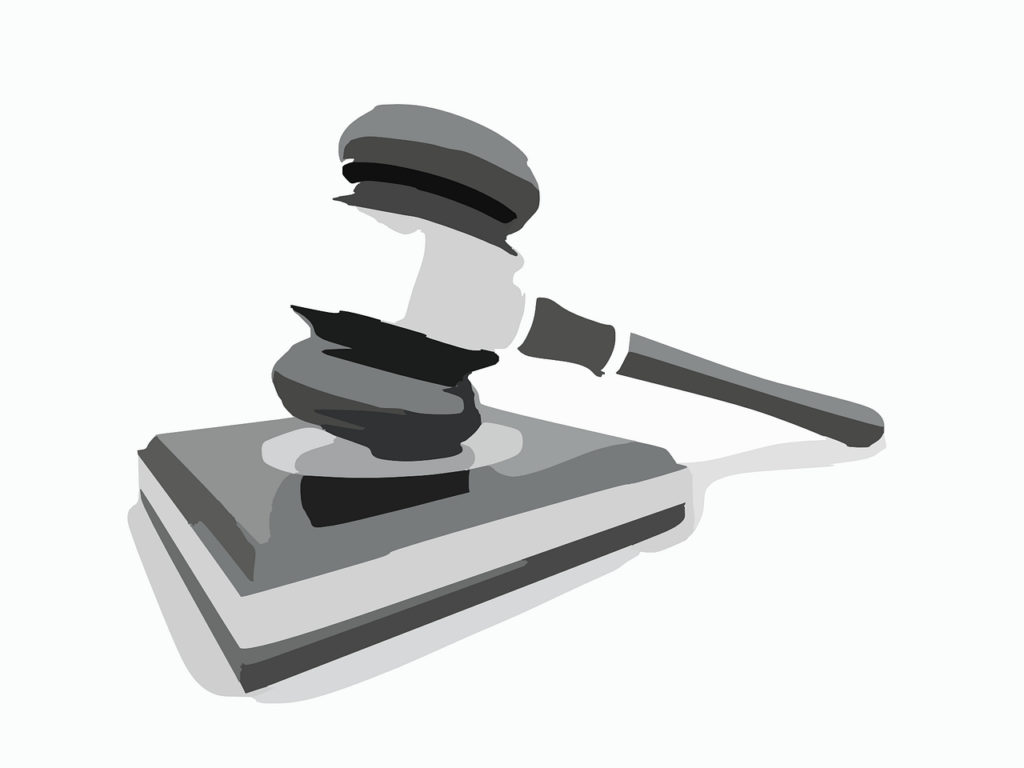 Grayscale illustration of a judge's gavel in mid-strike on a sound block, indicating the action of delivering a verdict.