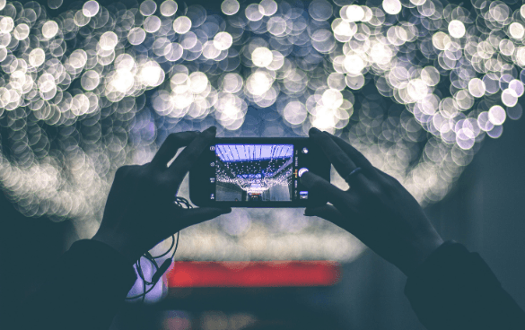 A person takes a photo of lights with their smartphone