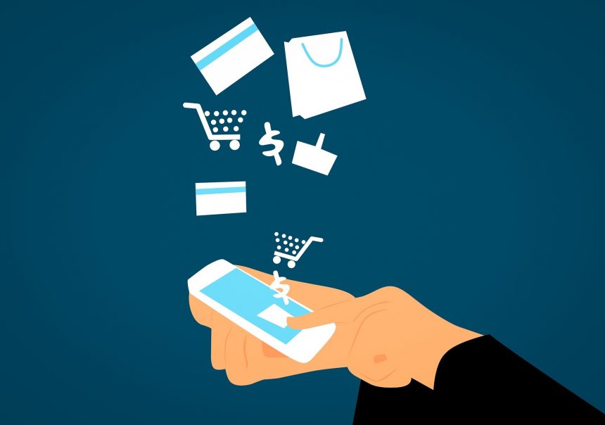 Hand holding a smartphone with a gift bow on the screen, surrounded by shopping and finance icons like a shopping cart, credit card, shopping bag, and currency symbols against a dark blue background.