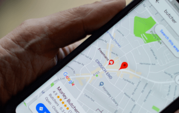 A person's hand holding a smartphone with Google Maps open, displaying the Crouch End area on the screen.