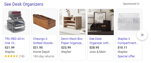 A selection of desk organizers with prices and store names, including a TRU RED 10-compartment organizer, a Cheungs 2-slotted wooden organizer, a Devin stack box paper organizer, a Dee desk organizer with drawers, and a Staples 3-compartment organizer.