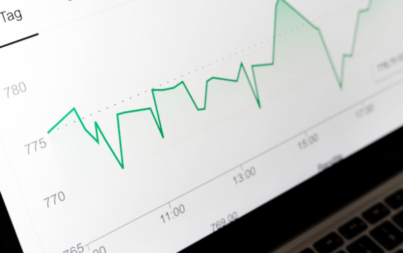 Close-up view of a computer screen displaying a green line graph with fluctuating data points over time, including numerical values on the y-axis and time stamps on the x-axis.