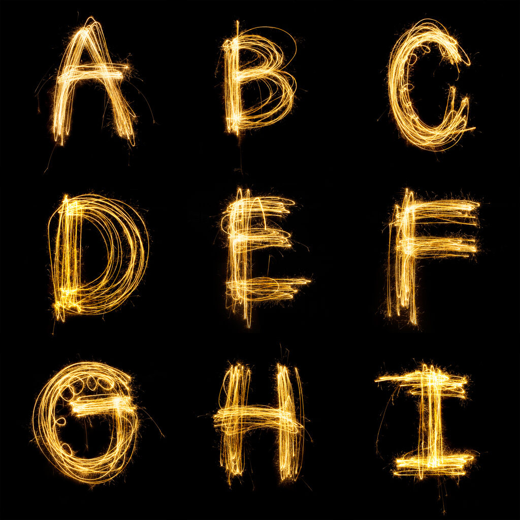 Collection of sparkler firework light alphabet isolated on black background.