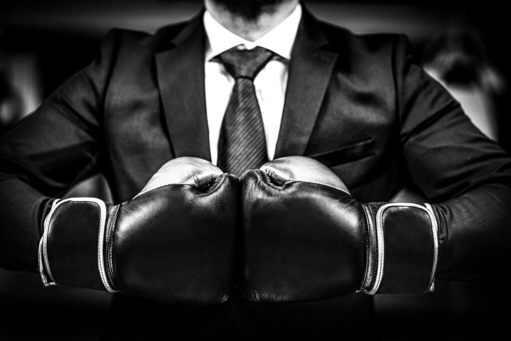 Businessman with boxing gloves is ready for corporate battle.