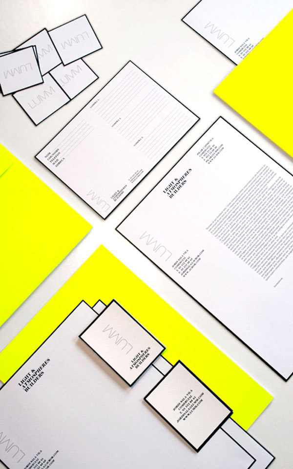 Assorted stationery items including business cards, letterheads, and envelopes with a minimalist black and white design and bright yellow accents.