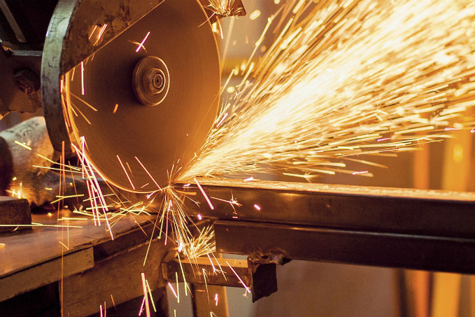 Close-up of a grinding wheel in contact with metal, emitting a shower of bright sparks during a metal grinding process.