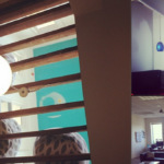 Collage of six photos depicting various scenes: an office environment with people working, a decorative light fixture, an upside-down room illusion, a group of people in festive attire, an empty office space with sunlight, and a close-up of a beer bottle with a kangaroo label.