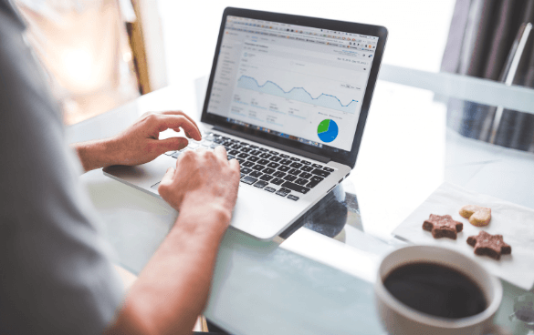 A person sits in front of a computer with Google Analytics data on the screen