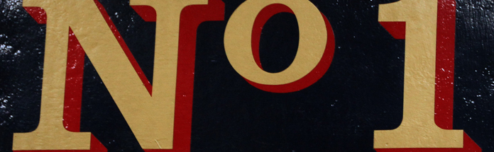 Close-up of a sign with the letters 'NO1' in bold red and gold colors.