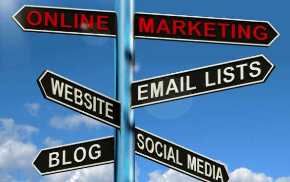 Signpost with directional signs against a blue sky, indicating different aspects of online marketing: ONLINE MARKETING, EMAIL LISTS, SOCIAL MEDIA, BLOG, and WEBSITE.