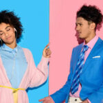 A woman in a pink robe with headphones enjoys music on her phone, dancing with her eyes closed, while a man in a blue suit looks at her with a puzzled expression, pointing at her and holding his phone.
