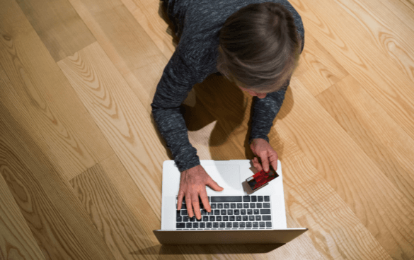 Woman laying on the floor shopping on her laptop