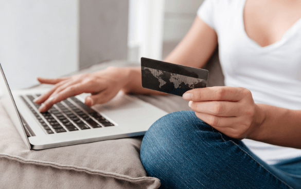 Woman shopping on a laptop with her credit card in hand