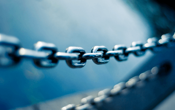 Close-up of a metal chain with a shallow depth of field, set against a blurred blue background.