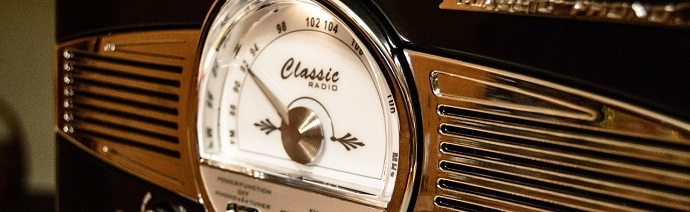 Close-up of a vintage-style radio with a dial labeled 'Classic Radio', featuring a circular frequency display and a retro metallic design.