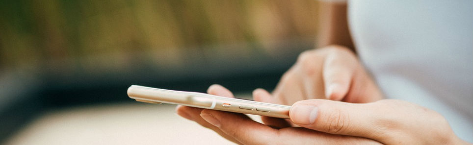 Close-up of a person's hands holding and using a smartphone.