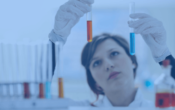 A scientist in a lab coat comparing the contents of two test tubes with red and blue liquids in a laboratory setting.