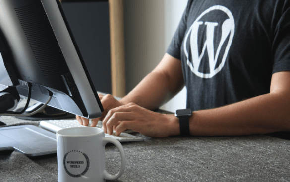 Man typing on a computer while wearing a WordPress shirt