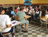 Students seated at desks in a classroom, focusing on an activity or lecture not visible in the image.