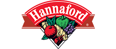 Logo of Hannaford featuring the brand name in red with a green and red ribbon above and below the text, accompanied by illustrations of a tomato, garlic, and grapes.