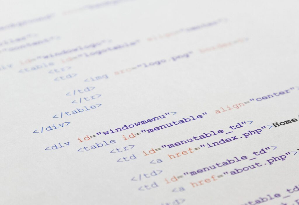 Close-up of a printed HTML code snippet with tags and attributes, slightly blurred with focus on the center.